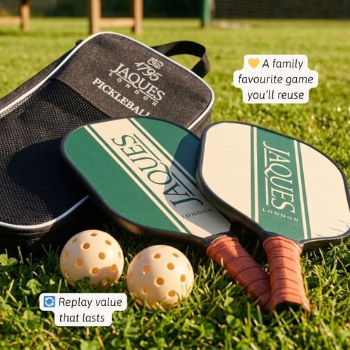 Two pickleball paddles and two balls with a carrying case on grass, featuring Jaques of London branding. 
