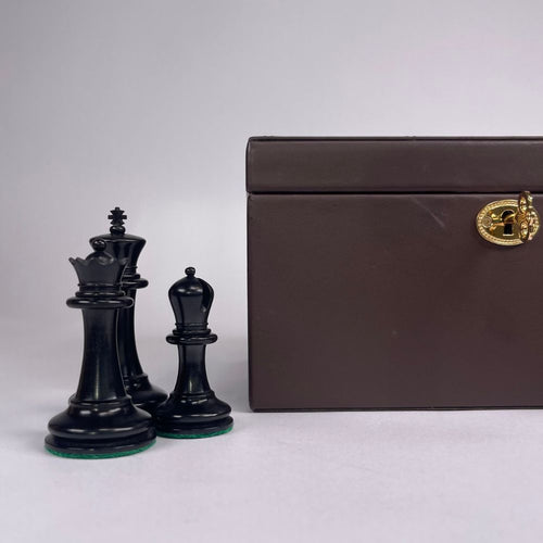 Black chess pieces with a brown storage box on a white background 