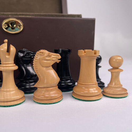 Set of wooden chess pieces with a brown box in the background 