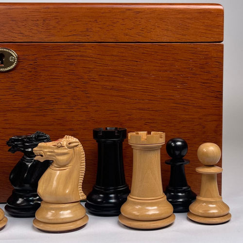 Wooden chess pieces in front of a wooden chessboard box 