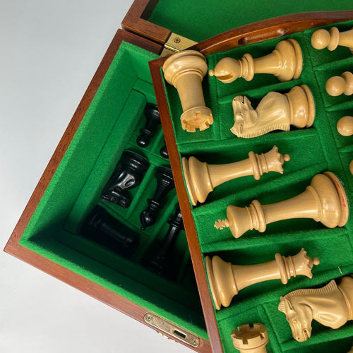 Chess pieces in a wooden box with green felt lining 