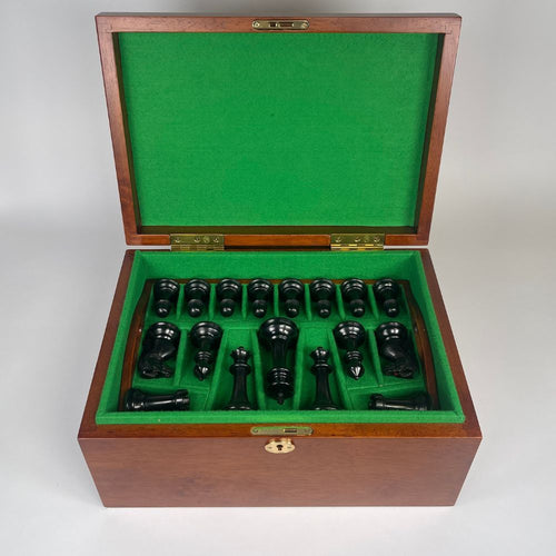 Wooden chess set with green felt interior on a white background 