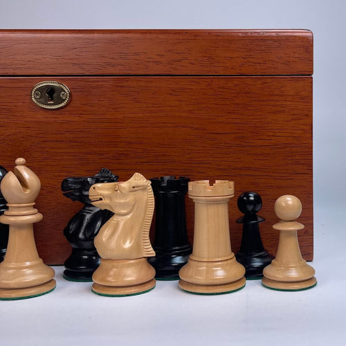 Wooden chess pieces in front of a wooden chessboard box 