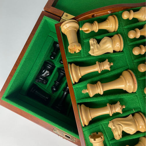 Chess pieces in a wooden box with green felt lining  