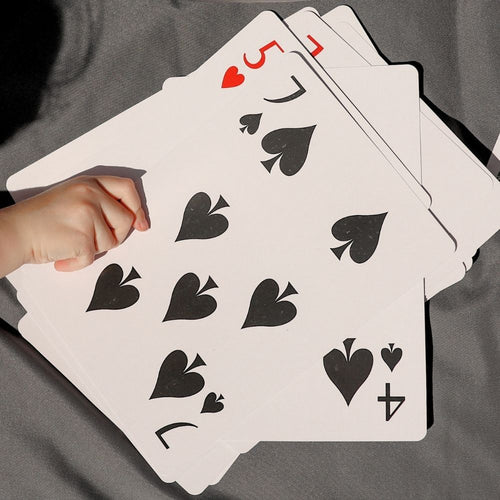 Playing cards with black symbols on a gray surface
