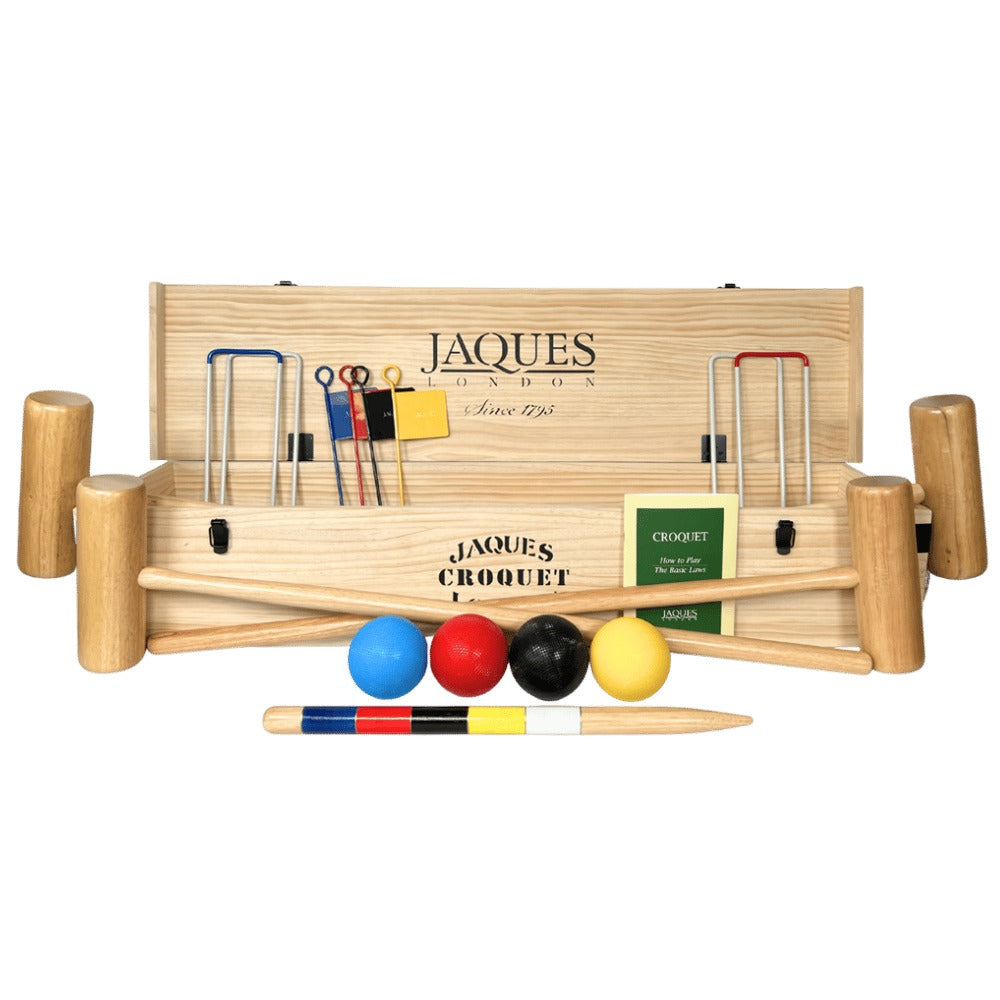 Croquet set with wooden mallets, balls, and flags on a green background 