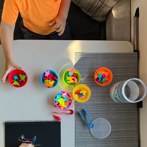 Child playing with colourful toys on a table. 