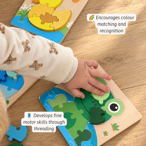 A child's hand wearing a cream knit sweater with teddy bear patterns is actively playing with a wooden frog puzzle on a light wood floor. The image includes text callouts highlighting the educational benefits of the toy.