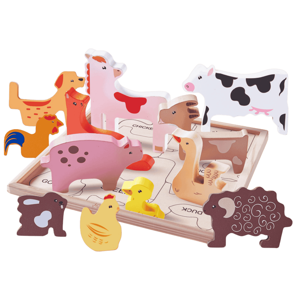 Set of wooden farm animal toys on a green background 