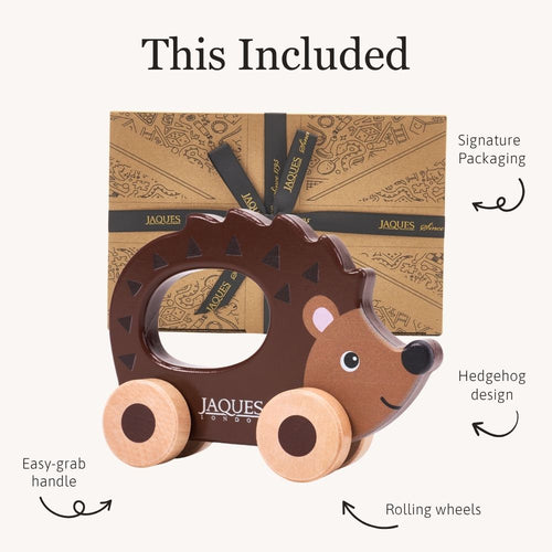 Wooden hedgehog toy with rolling wheels and an easy-grab handle, displayed in front of Jaques packaging. 