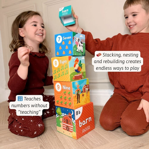 Two children playing with educational number blocks on a wooden floor. 