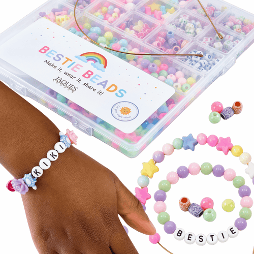 Colorful beaded bracelets and a box of Jaques Bestie Beads on a green background[fill]