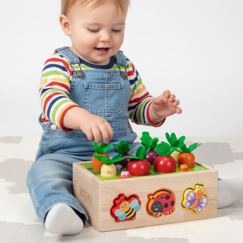 Toddler playing with wooden garden shape sorter toy featuring colourful vegetables and animal shapes for early learning 