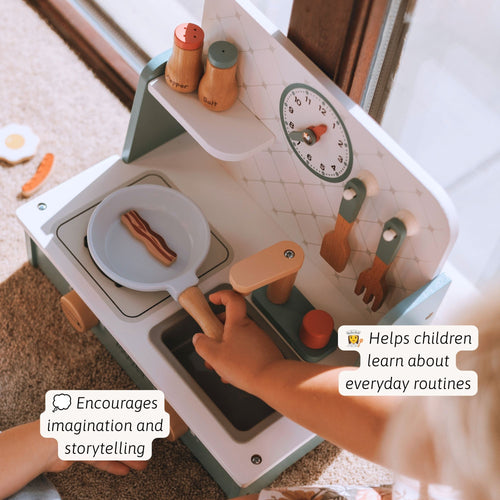 A child's wooden play kitchen set with a frying pan, utensils, and a clock, shown in a home setting with a child's hands interacting with it. Text overlays highlight its benefits for imagination and learning.