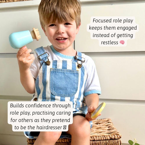A child using the toy hairdryer and brush during pretend salon play 