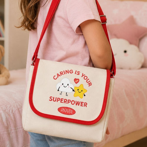 Person holding a white bag with red straps featuring a motivational message and cartoon characters. 