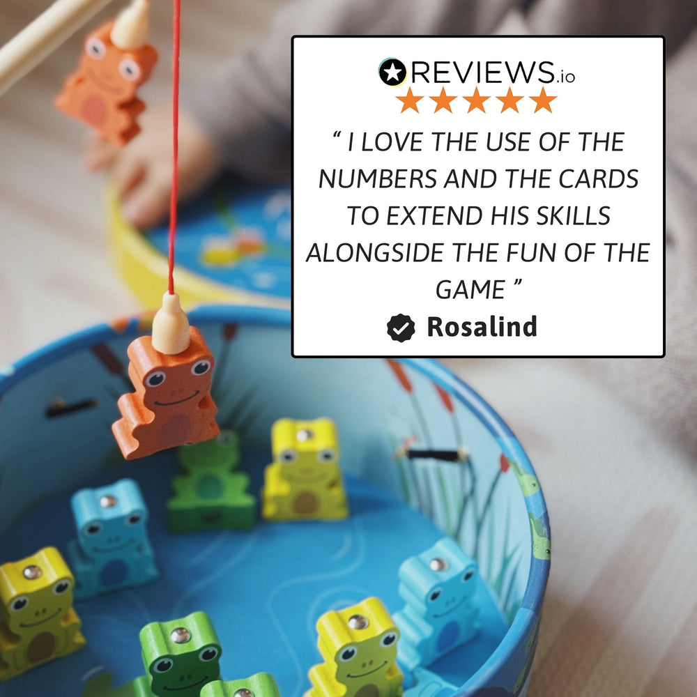Close-up of a wooden frog being lifted by a magnetic fishing rod from the blue pond game, with a five-star customer review overlay 