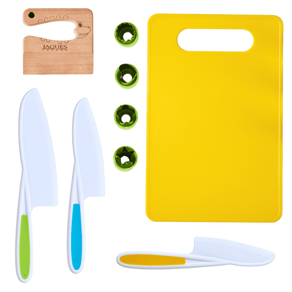 Set of knives, a yellow cutting board, and small green items on a transparent background 