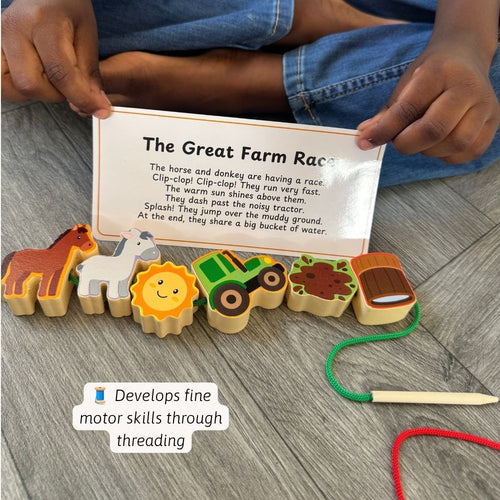 A child's hands hold a printed card titled 'The Great Farm Race' above a set of wooden farm-themed beads and a wooden threading tool on a gray wood floor. The beads include a horse, donkey, sun, tractor, mud, and barn, connected by colored threads.