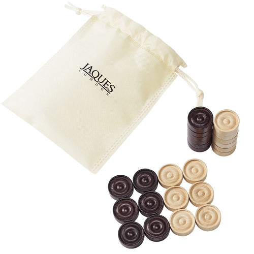 Wooden draughts pieces next to drawstring bag