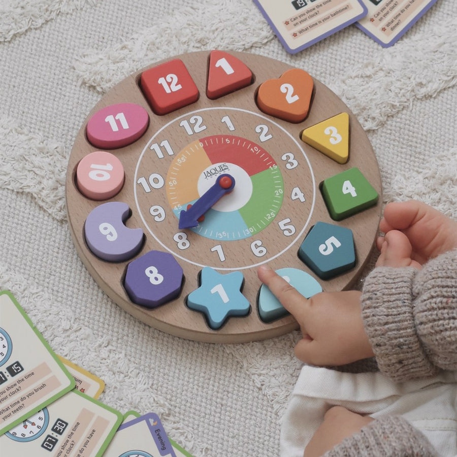 Toddler pointing to the numbers on the Jaques of London wooden shape sorting teaching clock, Montessori time telling toy [fill]