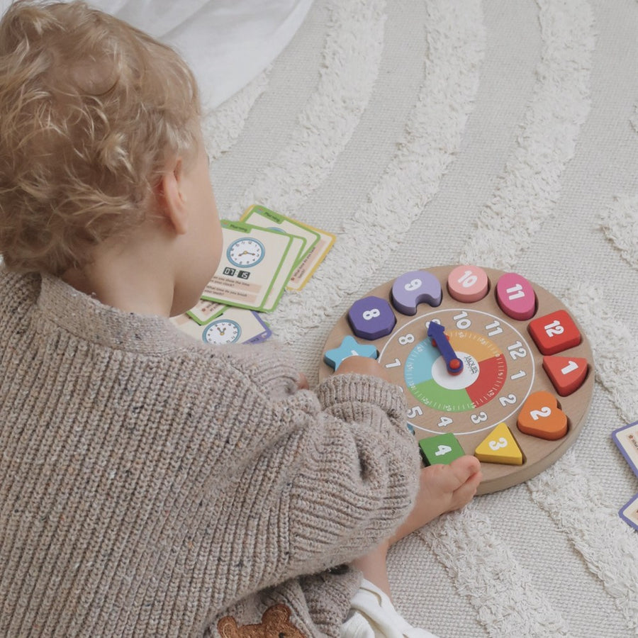 Toddler playing with the Jaques wooden teaching clock and time telling flashcards during floor play [fill]