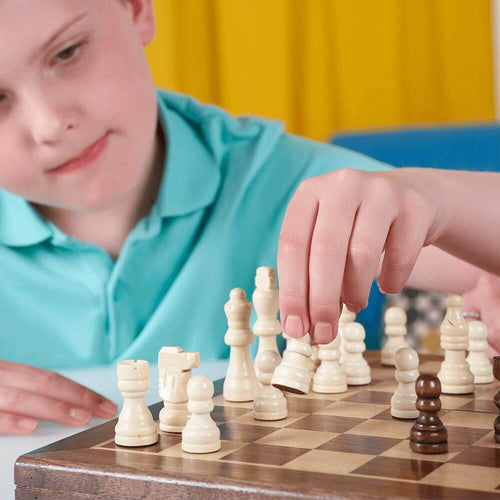  Thoughtful boy moving a chess piece on the board
