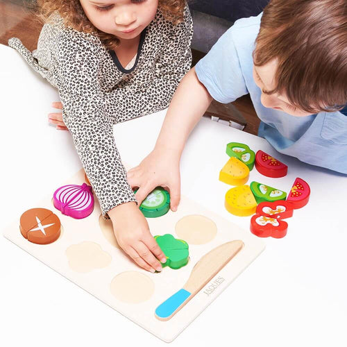  Children placing pretend vegetables on wooden board 